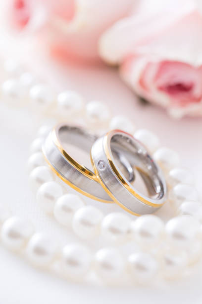 istock Modern wedding rings with pearl necklace with pink roses 1299248392