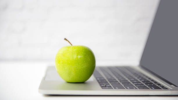 istock select focus. Healthy snack with working in the office.  Green apple with laptop on table.  Healthy Lifestyle Concept 1299249320