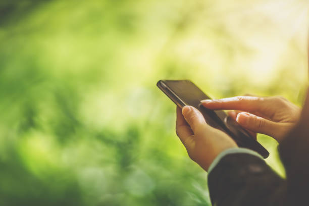 istock Young woman on nature using her smartphone 1299249381
