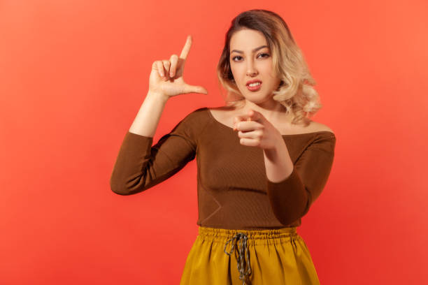 istock Young girl pointing her finger up and at the camera 1299249694