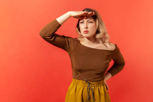 istock Woman holding hand above eyes and looking far away 1299249695