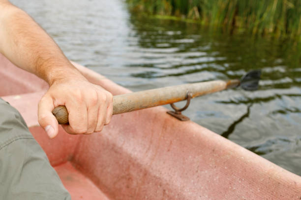 istock a man's hand squeezes an oar in his hand while sitting in a boat 1299249733