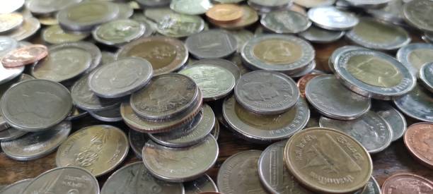 istock Many kinds of Thai coins on a wooden table 1299250287