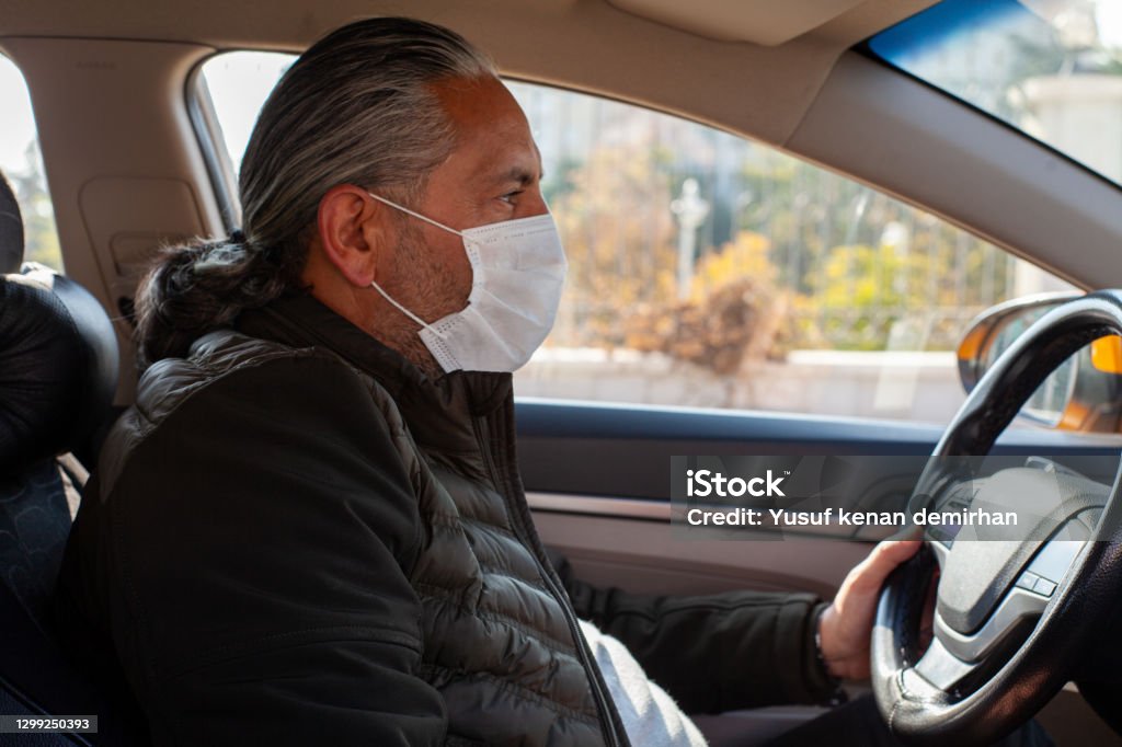 A taxi driver cares his customers' health. Wearing mask is obligatory now. Taxi Driver Stock Photo