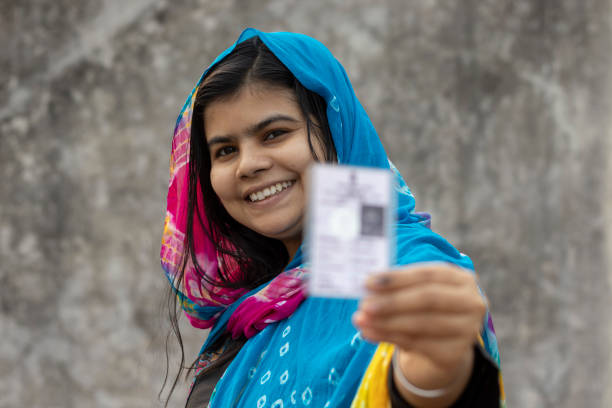 the largest democracy of India an Indian village woman with smiling face showing blurred voter card in hand constituency photos stock pictures, royalty-free photos & images