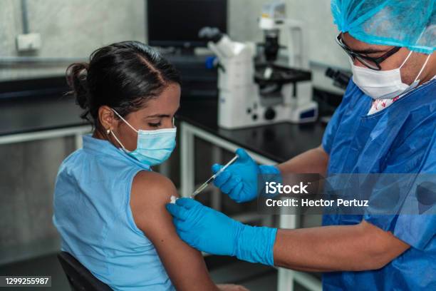 Young Woman Receiving Coronavirus Vaccine Stock Photo - Download Image Now - Vaccination, COVID-19 Vaccine, Coronavirus