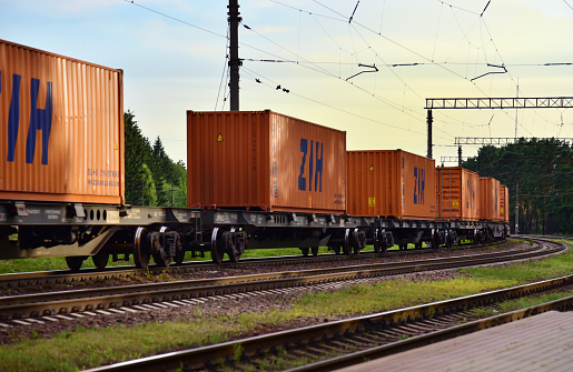Shipping containers of ZIH Zhengzhou International Hub transportation on cargo train by railway. China-Europe freight trains. Object in motion, soft focus. Russia, Smolensk region, JULY 10. 2020