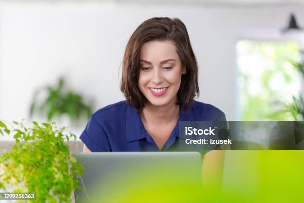 Smiling Woman Working On Laptop At Home Stock Photo - Download Image Now - Laptop, 30-39 Years, Adult