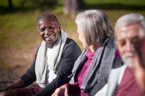 istock Senior african-american man resting with friends on bench after exercise 1299257680