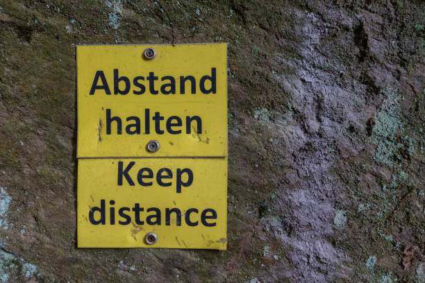 istock yellow sign on a rock with keep distance while hiking 1299257991