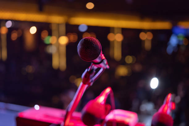 istock A microphone on stage concert with colorful lighting laser beam spotlight show in disco pub club bar background for party music dancing festival performance. Entertainment nightlife. Celebration event 1299259469