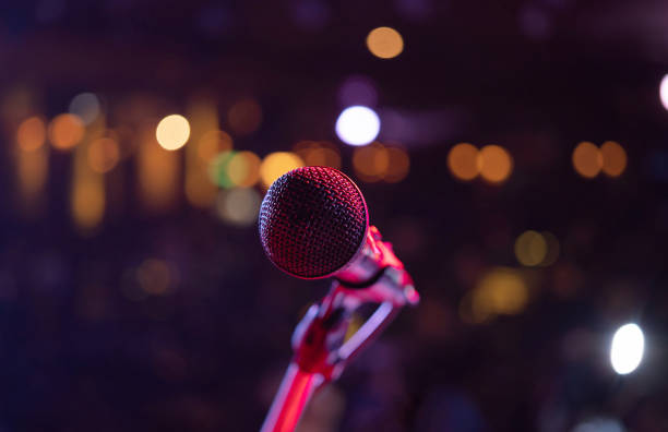 istock A microphone on stage concert with colorful lighting laser beam spotlight show in disco pub club bar background for party music dancing festival performance. Entertainment nightlife. Celebration event 1299259562
