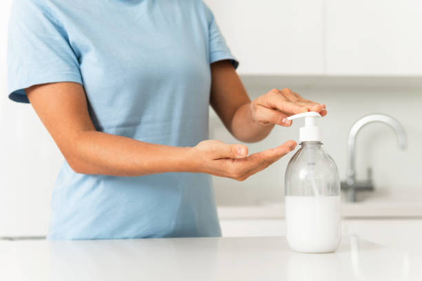 istock Woman using hand sanitizer or liquid soap for hands disinfection 1299259719