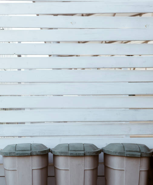istock White wooden planks background with three plastic garbage trash bins down 1299260611