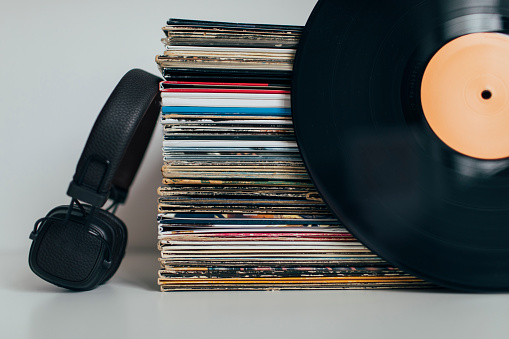 Headphones with stack of vinyl records collection.