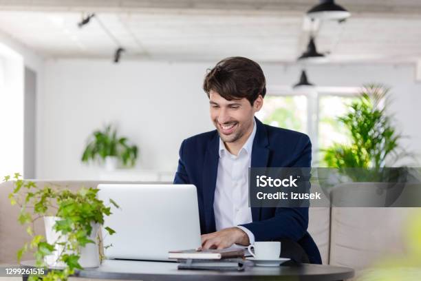Businessman Working On Laptop In The Green Office Stock Photo - Download Image Now - Blue, Laptop, Office
