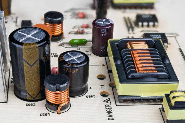 istock Electronic components on printed circuit board detail. Coils with ferromagnetic core 1299261943
