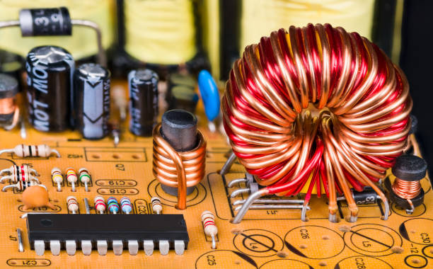 istock Toroidal or cylindric inductors on printed circuit board with electronic components 1299261946