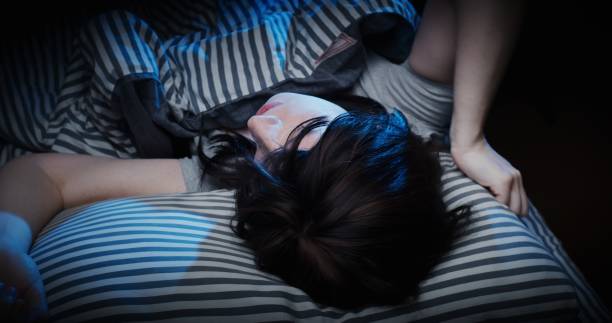 istock Mature woman is waking up and stretching in bed 1299262002