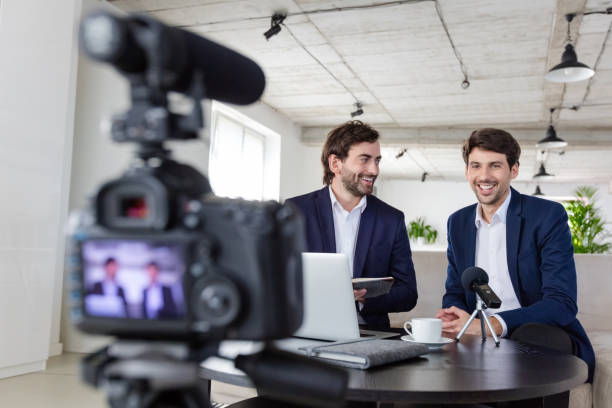 istock Businessmen making a video blog in the office 1299262250