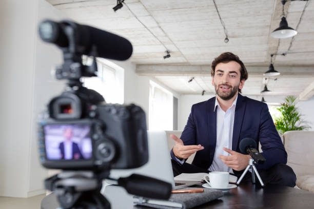 istock Cheerful businessman making a video blog in the office 1299263446
