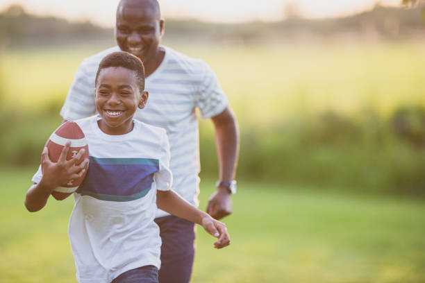 istock Father and son playing backyard football 1299264129