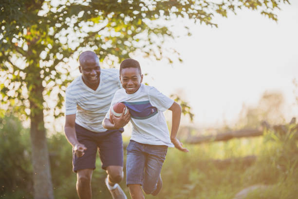 istock Father and son playing backyard football 1299264135