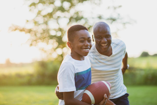 istock Father and son playing backyard football 1299264136