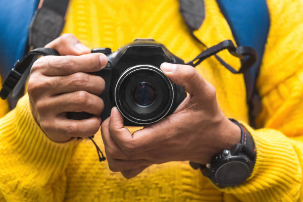 istock hands of a man holding a professional camera. travel concept. 1299264265