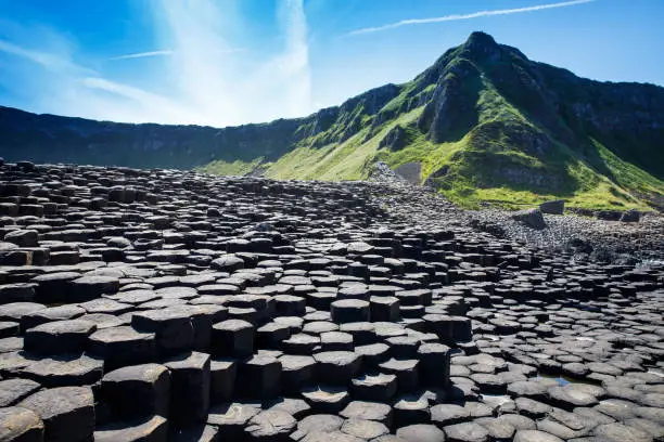Landscape of Giant's Causeway trail with a blue sky in summer in Northern Ireland, County Antrim. UNESCO heritage. It is an area of basalt columns, the result of an ancient volcanic fissure eruption.