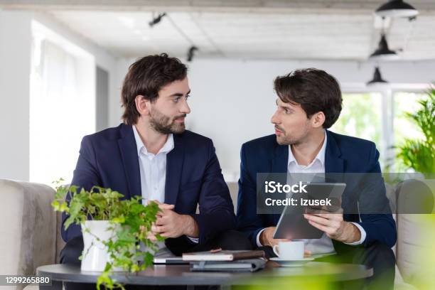 Shareholders Discussing Over Digital Tablet Stock Photo - Download Image Now - 30-39 Years, Adult, Adults Only