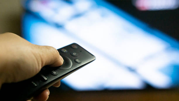istock closeup of a hand holding a remote control for the television 1299271467