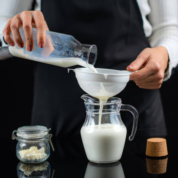 istock Pouring Milk Through a Stainer with Kefir Grains. Making Kefir at Home. 1299271783