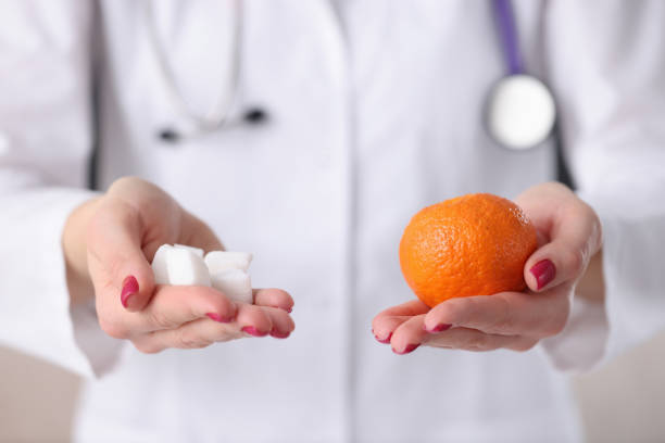 istock Doctor holding orange and sugar cubes in his hands closeup 1299273736