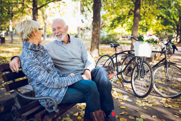 istock Senior couple relaxing on bench in the park 1299275680