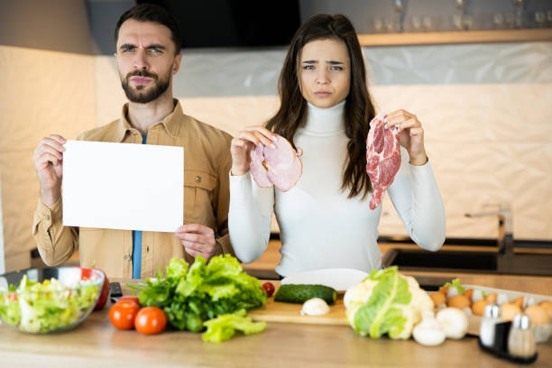 Young vegetarian couple is showing that they don't like eating meat and prefer fresh vegetables to it. Healthy lifestyle without meat Young vegetarian couple is showing that they don't like eating meat and prefer fresh vegetables to it. Healthy lifestyle without meat . dont eat meat stock pictures, royalty-free photos & images