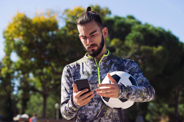 istock sportsman looks his phone with confused expression 1299275957