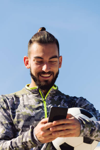 istock happy sportsman laughing looking his cell phone 1299275965