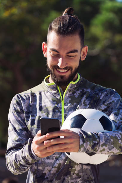 istock happy sportsman writing a message on his phone 1299275966