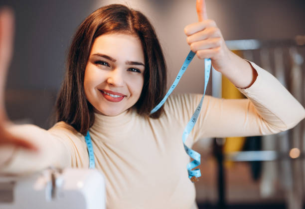istock Young dressmaker woman taking selfie. Seamstress in workshop 1299276033