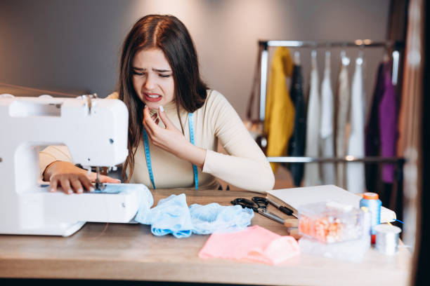 istock Young dressmaker woman sews clothes on sewing machine. Making mistakes or something went wrong seamstress in workshop. Creating online clothing design courses. 1299276044