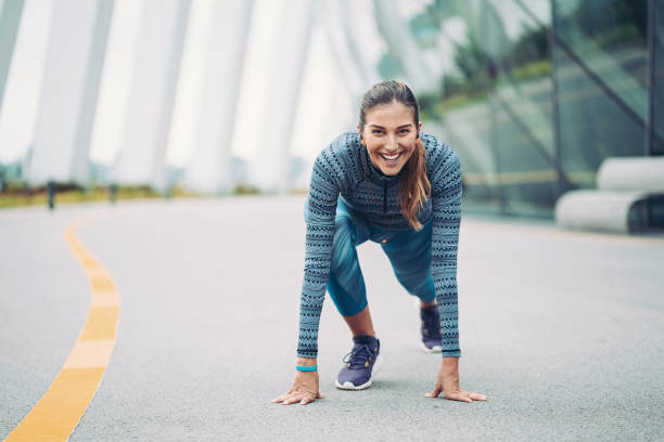 istock Smiling sprinter in a starting position on the track field 1299276082