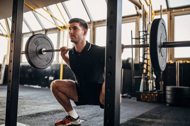 istock Muscular man exercising with weights in gym 1299276784