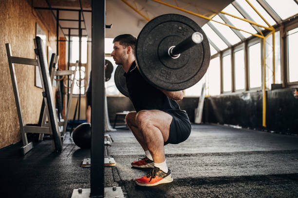 istock Muscular man exercising with weights in gym 1299277474