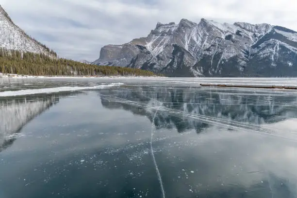 Reflections in frozen Lake Minnewanka in Banff National Park, Alberta, Canada