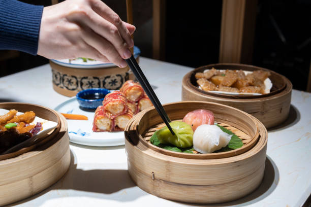 istock A hand taking the Guangdong dum sum named Three-colored Shrimp Dumplings with chopsticks 1299279693