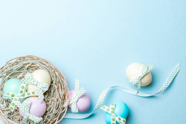 istock Easter eggs isolated. Colorful egg with tape ribbon on pastel blue background in Happy Easter decoration. Flat lay, top view. 1299279736
