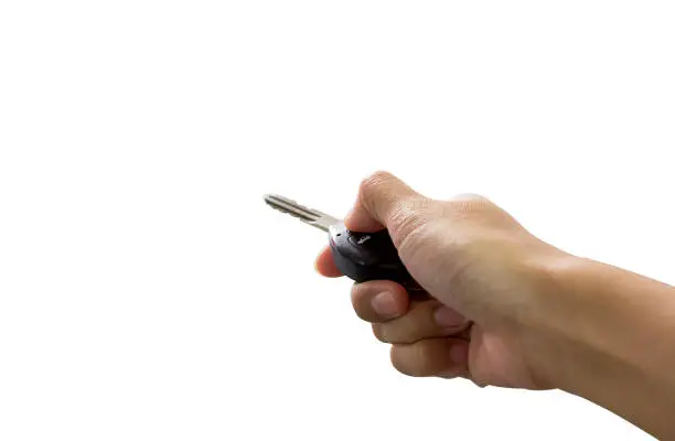 Photo of Female hand holding a car key isolated on white