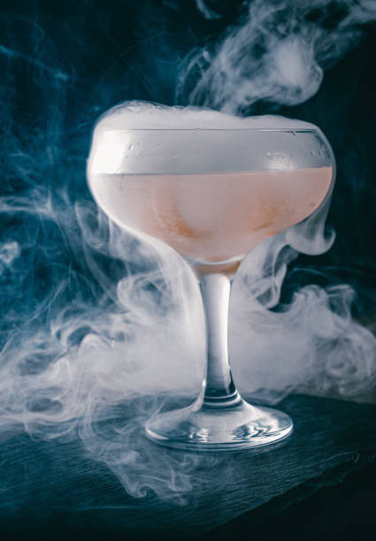 istock Alcohol cocktail in the glass with smoke on dark background. 1299280808