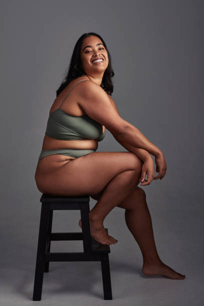Loving yourself is the greatest revolution Shot of a young woman posing in her underwear against a grey background body positive stock pictures, royalty-free photos & images